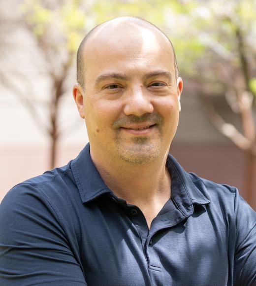 A professional headshot of Nitzan Shabek, CEF Faculty Director. He is smiling at the camera, wearing a blue polo shirt.